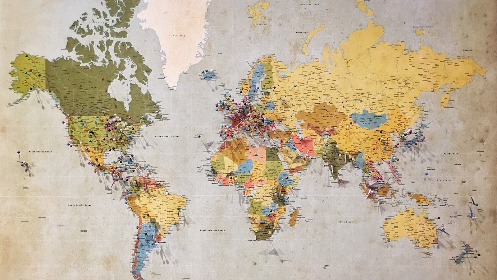 A world map covered in colourful push pins marking dozens of locations across different countries and markets